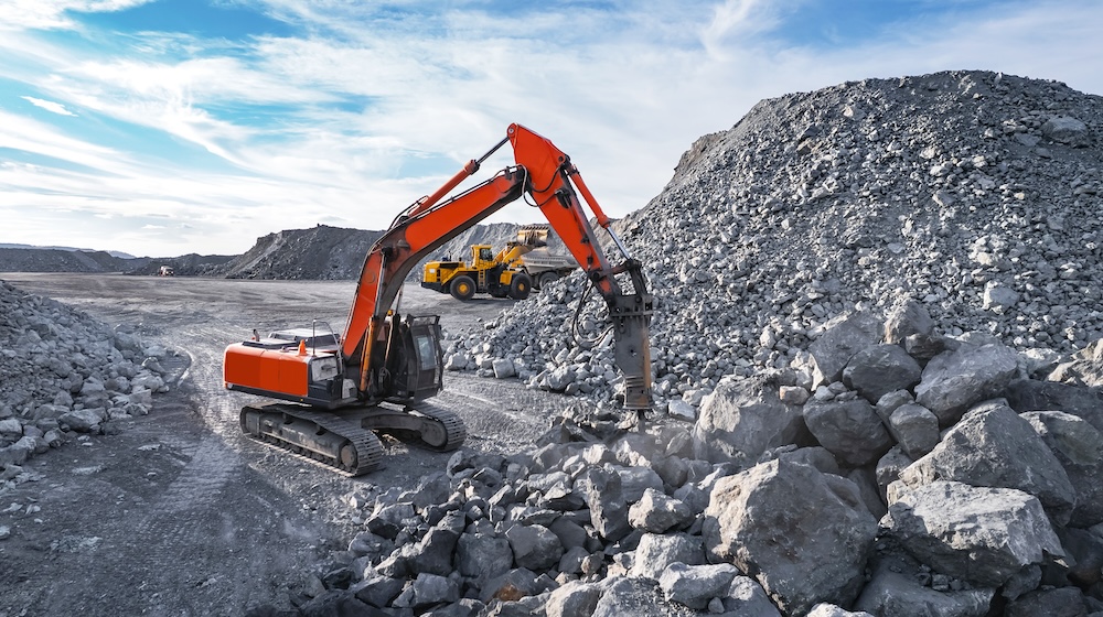 Open pit mine industry, Excavator Hydraulic hammer for crushing oversized rock ore aerial photo by drone